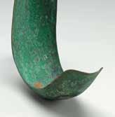 It now appears green or teal due to the surface patina a tarnish or rust that builds up over time when metals are exposed to