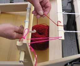 Put the heddle hook into the slot where you marked your heddle to start Place the yarn on the hook and pull the loop through the slot.