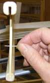 Start in the center of the heddle. Select 6 or 8 yarns and stroke them to straighten them. Divide them in the middle into two parts, half on the right and half on the left.
