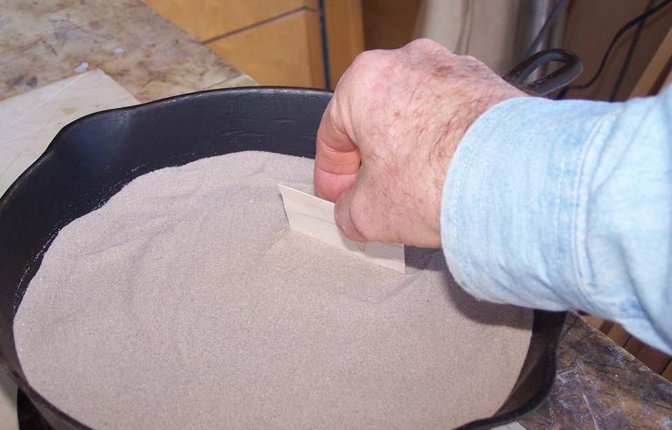 Use your piece of scrap veneer to test when the sand is hot. Just stick the veneer into the sand a bit not all the way that it hits the bottom of the pan.