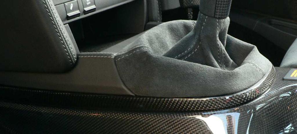 Place the carbon fiber shift boot surround in position and screw in
