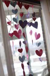 Heart Garland colored paper scissors string or yarn tape Fold paper in half and cut a heart out, repeat to make lots of hearts.