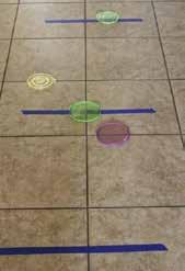 Frisbee Toss plastic lids painter s tape Tape lines of tape on the floor about a foot apart.