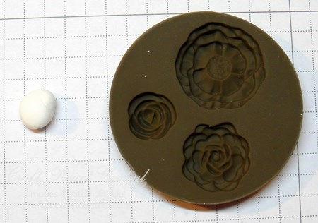 Press the clay ball into the smallest flower in the mold.