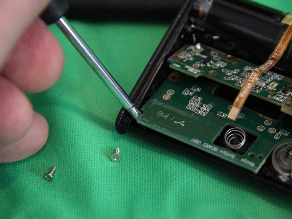 Step 6 Insert a small flat blade screw driver as shown and gently pry the lower PCB