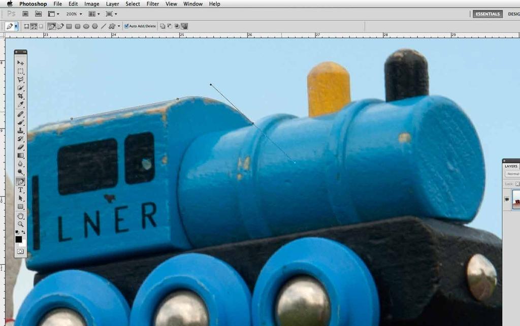 Pick the Pen tool (P) and click on the image to place an Anchor point between the edge of the blue train and the background.