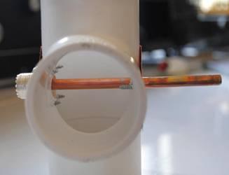 Fill the short length of tubing with solder then heat it a push it over the center conductor of the SO-239 and heat generously.