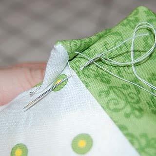 {green} Fold the triangle up and stitch it in place with a small, hand-sewn tack stitch.