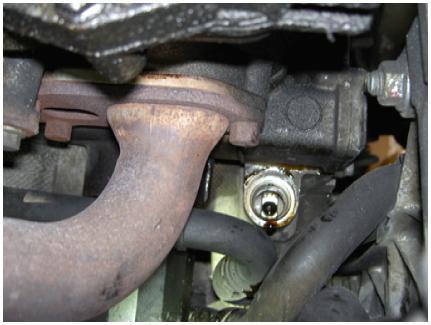 With a catch bin in place, remove the oil drain plug and completely drain the engine oil.