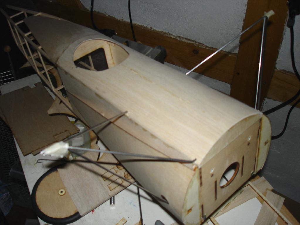 Select hard balsa or basswood for the longerons. Join the two frames over the plan with cross braces and the tail skid mount. Use elastic cord or a spring to make the tail skid shock absorber.