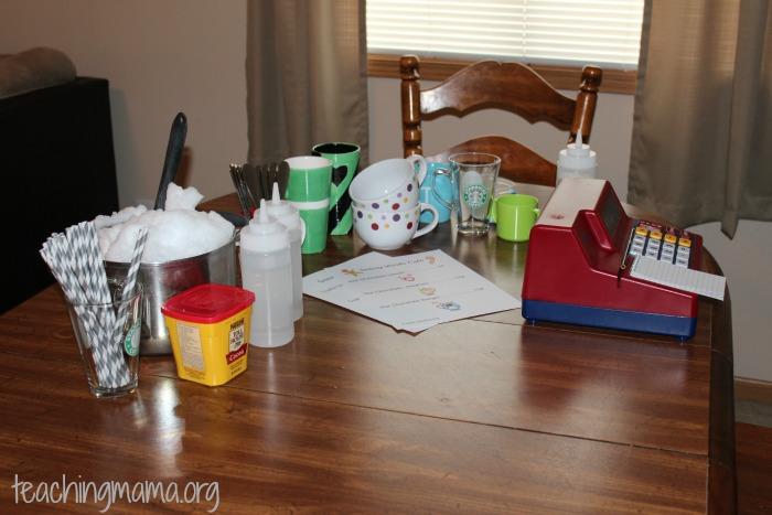 Invitation to Play: Set out the cups, mugs, cash register, and other materials.