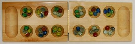 1 Introduction to Mancala Mancala is a two-player game from Africa in which players moves stones around a board (shown above), trying to capture as many pieces as possible.