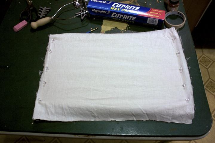 Step 3: Stretch the fabric across the frame (cardboard) and pin it in place.
