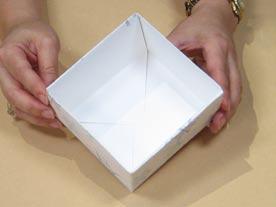 6 Fold the box lid. Starting with the bottom folded side, fold the outermost triangles in on themselves. Fold the bottom edge up and the two cut sides in. Repeat with the top folded side.