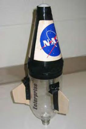 4. Press a small round ball or modeling clay into the top of the nose cone. 5. Glue or tape the nose cone to the upper end of your rocket (the bottom of the bottle) so that it may be easily removed.