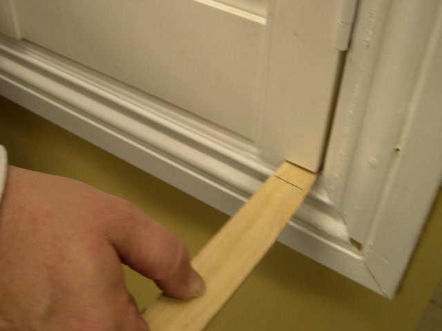 After you have evened the height gap, make a small mark where the top hinge will be installed on the window jam