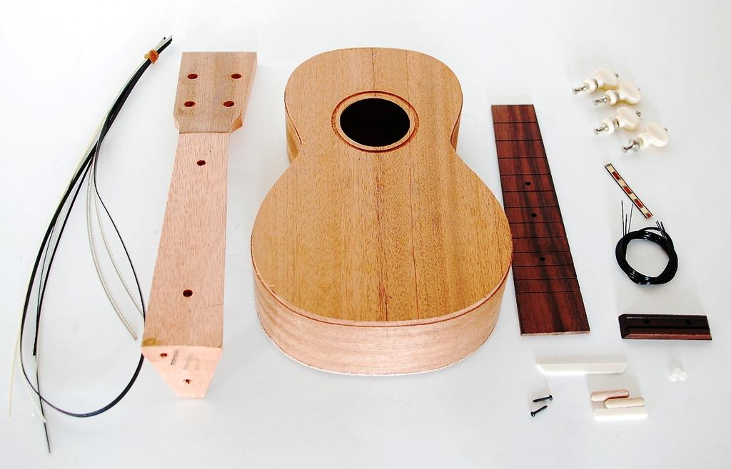 The already finished body of the instrument consists of laminated lime (in relationship to the production line it could be also mahogany), the fretboard (all frets are still assembled) is made of