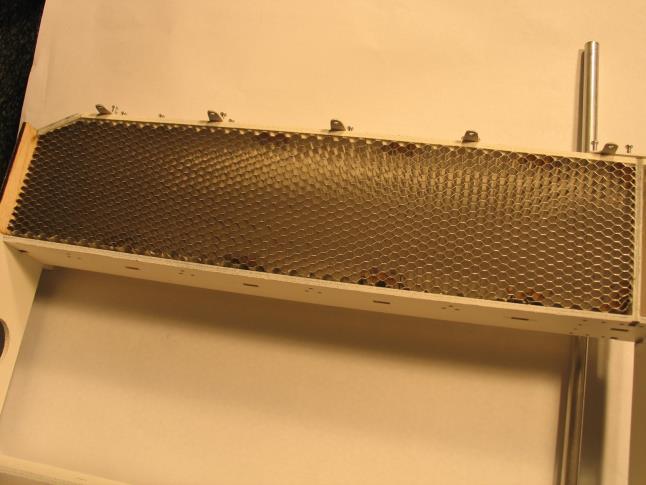 The honeycomb grill should be flush with the front of the wooden frame. See photos below The two center metal shields #4.7, 4.8 are held in place with aluminum clips #4.