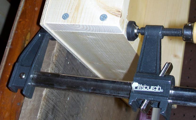 Use the pipe clamps to clamp the side frame to the bottom plywood base, as