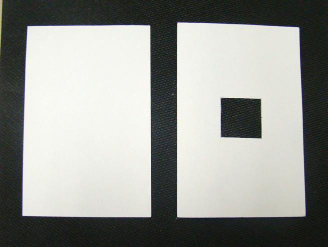 Place the uncut index card on the windowsill or on a table under a light source. Place the index card with the cut-out square hole beside it.