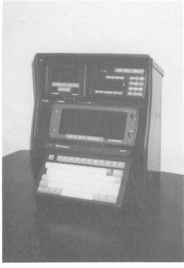 Exhibit 3-3. Mockup of Los Angeles City Fire Department mobile communications equipment. The MDT display and keyboard are at bottom of cabinet; automatic vehicle locator and radio control are at top.