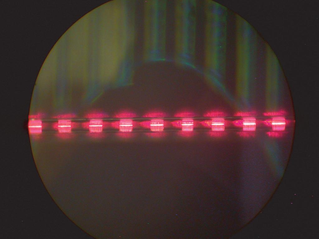 Figure 9.17(a) shows an optical image from the second SS-FBG. Red light is again coupled into the fiber to better show the regions where grating exists on the surface of the D-fiber. Figure 9.