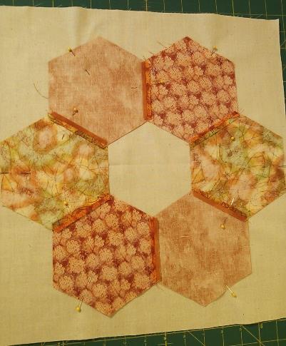 Stitch the hexagons in pairs along their adjacent sides.