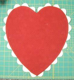 From the leftover piece of yardage, cut: 2 from the large heart template 2 from the small heart template Lay one of the large heart pieces out on your work surface, right side up.
