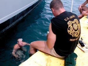 Divers find pier requiring repair work... (From Page 1) (Photo by Jim Bennett) Spc. Beau Woodcox calls out measurements to Staff Sgt. Steven Bonner.