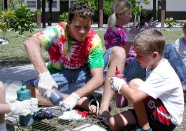 What s playing? Call the Movie Hotline, 52700. (Photo by KW Hillis) Brendan Greene helps David Bronson, 7, tie dye a T-shirt Saturday afternoon at the junior/senior high school.