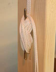 When the panel is at the desired height, wrap the cords around the rope cleat in a figure ''8'' pattern.