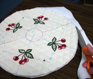 Lay the embroidered circle onto the Insul-Bright lining, pin in place, and cut