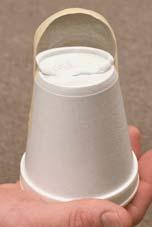Hold the lens in place with tape as shown in the picture at far right. Cut a slit in the bottom of another Styrofoam cup. Insert the velum screen into this slit. 3.