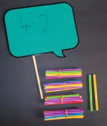 Player 1 lays out a 2-digit number represented by straws (e.g. 31), player 2 then lays out the number bond to 100 represented by straws.