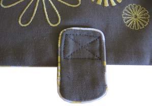 47. Place the snap tab on the embroidered purse flap so that the snap is just over the edge. Stitch an X formation as shown, to secure. 48.