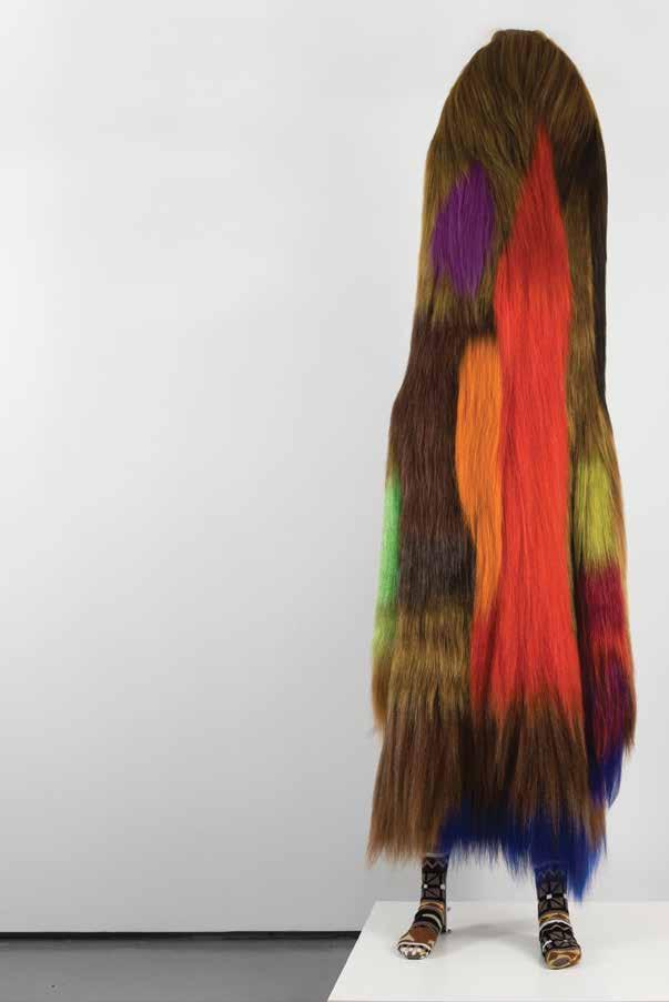 6 Art you can get into! Walk towards a tall, brightly patterned sculpture that looks like it is standing on legs and feet. This is a Soundsuit by Nick Cave.