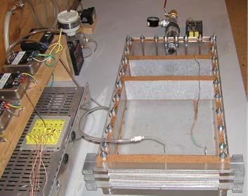 A counter flow 6 kw heat exchanger is shown in figure 6 below. A thin liquid section containing a dense 50 thick Al foam block (not shown in the photo) is sandwiched between (2) sections of airflow.