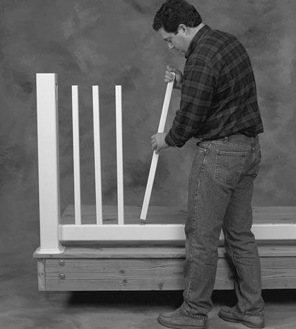 Pull up on the first few balusters and insert them into the top rail holes.
