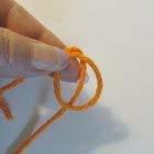 Loosely wrap the yarn behind and around your index finger and middle finger.