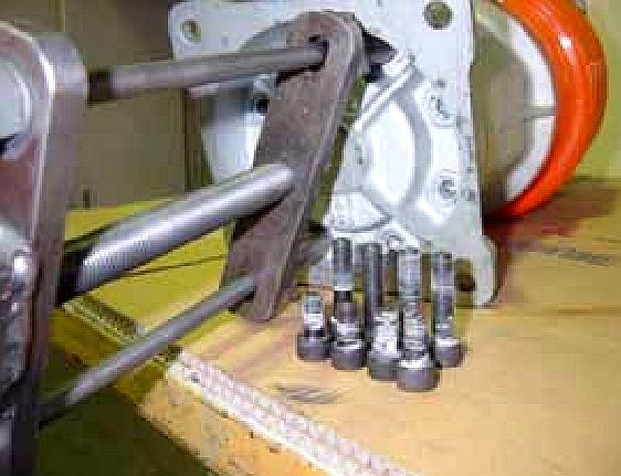 HOW TO USE THE SPRING TOOL CLOCKWISE After identifying and removing the two correct bolts from the foot plate on page (3), install the spring removal tool: Center Bolt Screw the two spring removal