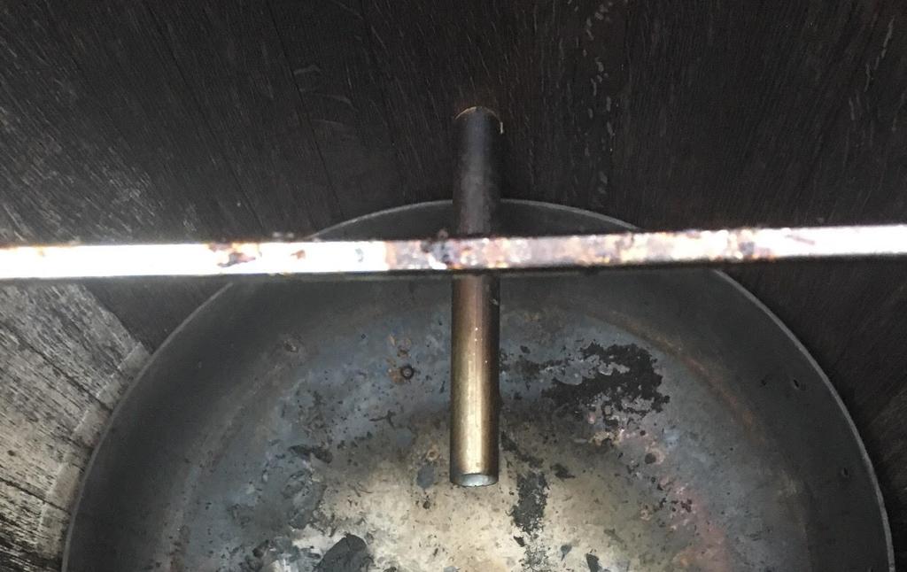 With a forstner attachment, drill one hole into the back of the barrel above the edge of the fire pit.