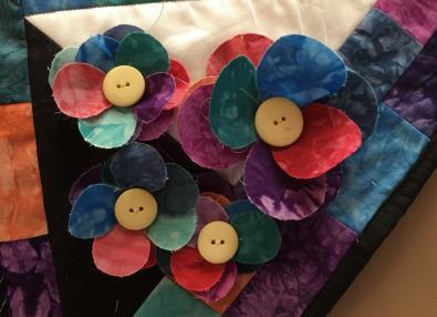 71. Back, quilt and bind as desired. Embellishments: 72. Sew the extra petals together using a gathering stitch. (5-10 petals per flower) 73.