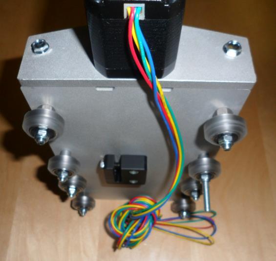 Set the X/Z assembly aside for a moment and grab the Z motor mount, a NEMA 17 stepper motor with a long cable, one motor coupler, four M3x10 button cap screws, and four M3 split-lock washers.