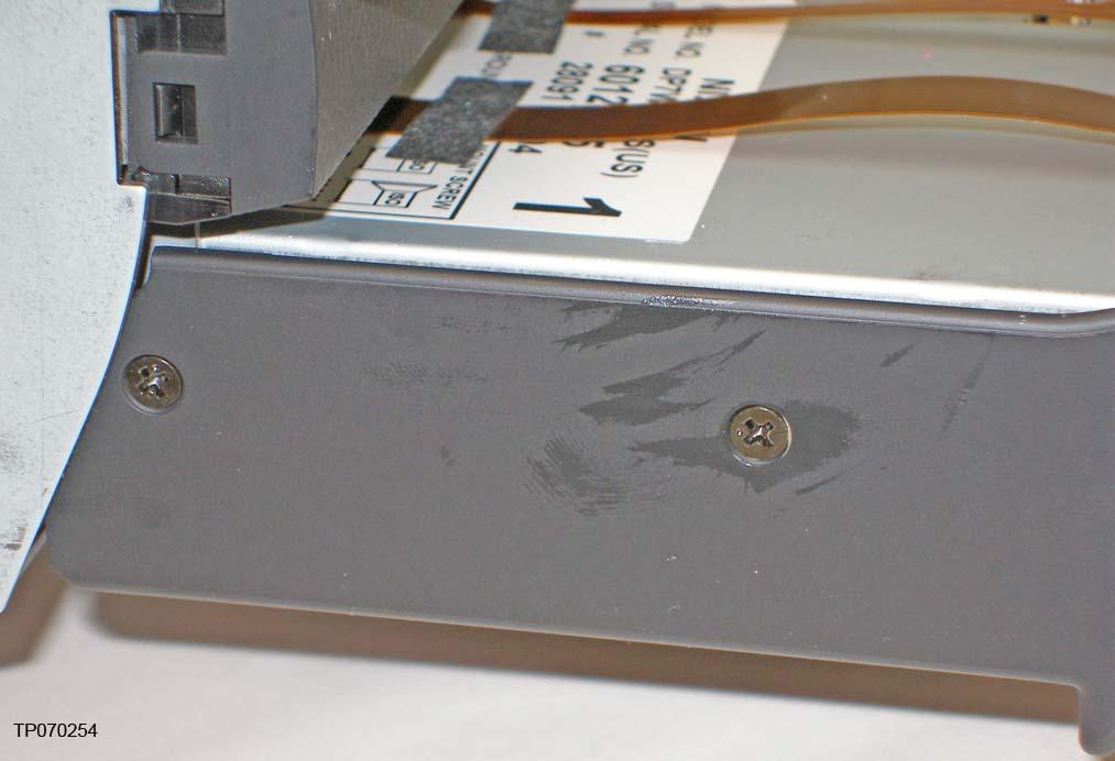 13. Remove the four pan-head screws (two shown) holding