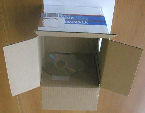 Next, set the box right-side-up, with the slit towards you. Now tape the CD disk onto the back wall of the box.
