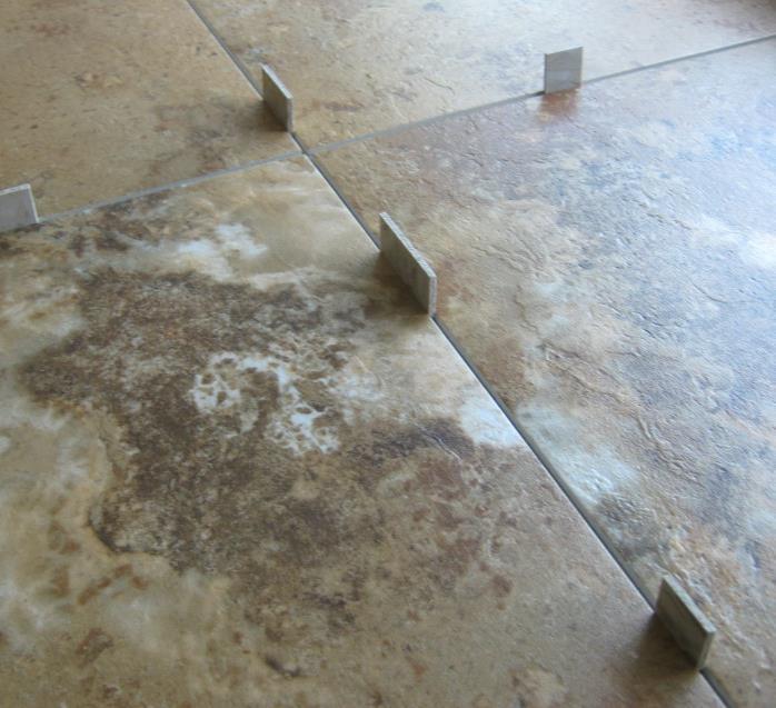 rounded edges on the tile or plank Remove spacers and thoroughly roll the tile or plank installation with a