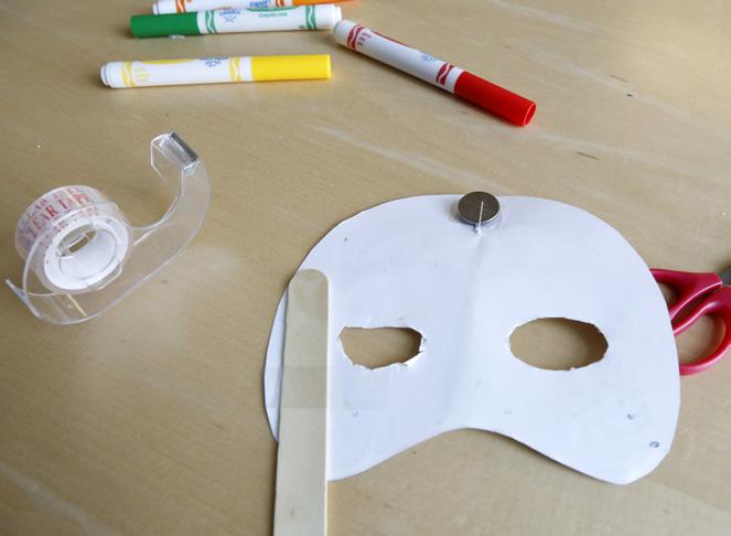 4. Try it on. Tape a craft stick to the back of the mask.