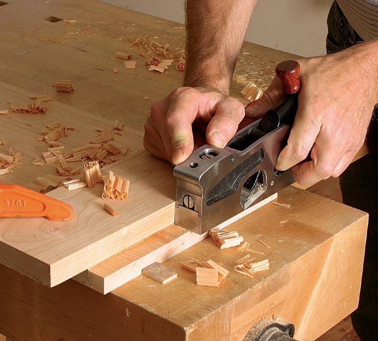 to accommodate heavier shavings, and then advance the blade for a medium cut. Hold the plane in both hands with its side firmly against the fence. Make multiple passes as needed.