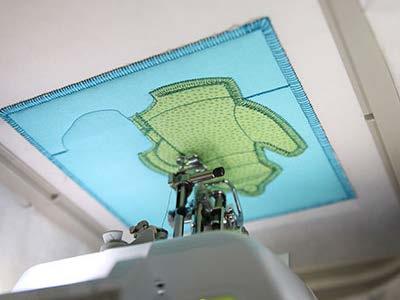 After the dieline is finished sewing, stop the machine, and remove the hoop, but do not unhoop the stabilizer.