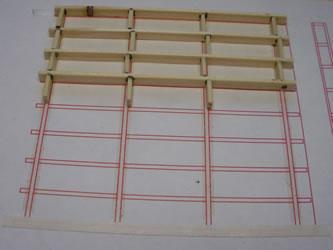 Attach double sided tape to the drawing to hold down the wooden floor joists and noggings. The floor joist and noggings are just regular soft wood cut down to approximately 1.5mm thick by 4.5mm wide.